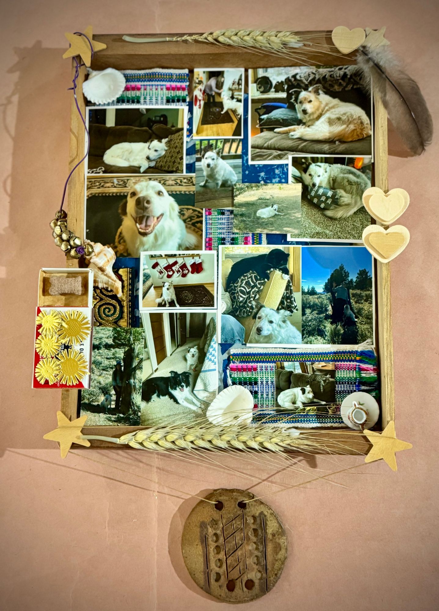 The framed dog-photo collage with a round clay medallion hanging from wheat stems below it.